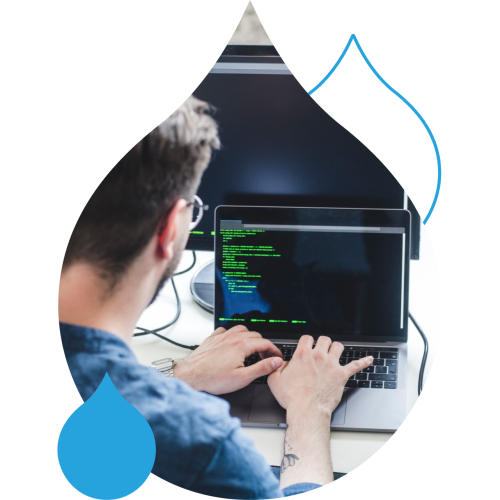 Picture of someone coding on a laptop in an acquia droplet mask