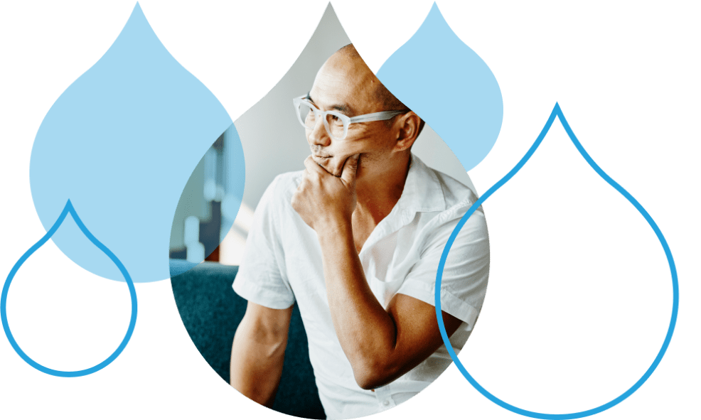 person with glasses surrounded by acquia droplets